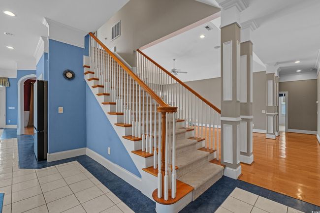 Stairs with tile patterned flooring, ceiling fan, ornamental molding, recessed lighting, and arched walkways | Image 29