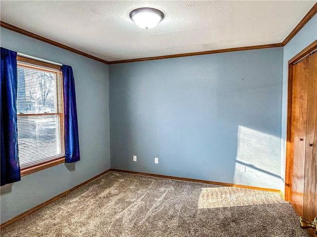 Spare room with a textured ceiling, carpet floors, ornamental molding, and baseboards | Image 17