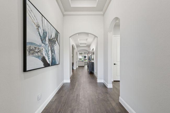 Corridor featuring arched walkways, dark wood-style flooring, and ornamental molding | Image 4
