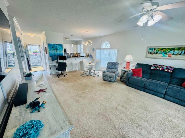 Carpeted living room with a textured ceiling and ceiling fan | Image 25