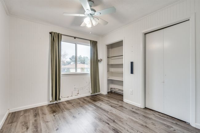 Unfurnished bedroom featuring ceiling fan, light hardwood / wood-style flooring, ornamental molding, and multiple closets | Image 15