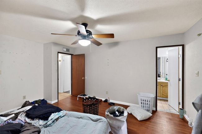 Bedroom with laminate wood finished floors, baseboards, a ceiling fan, and ensuite bath | Image 10
