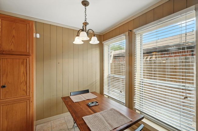 Dining space featuring a chandelier and wood walls | Image 6