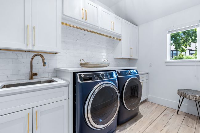 Laundry room featuring a sink with lots of storage space. | Image 22