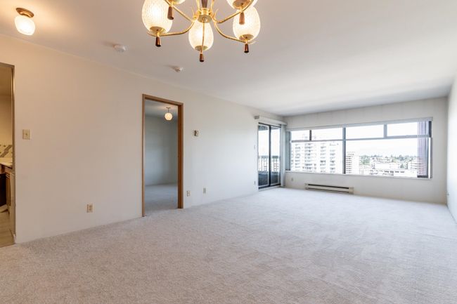 Interior space with a notable chandelier and a baseboard radiator | Image 5