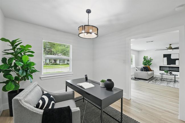 Home office with light wood-style floors, baseboards, a ceiling fan, and a chandelier | Image 19