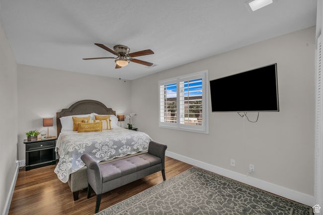 Bedroom with baseboards, wood finished floors, and a ceiling fan | Image 4
