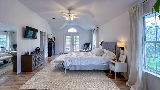Bedroom with french doors, lofted ceiling, wood finished floors, and a ceiling fan | Image 22