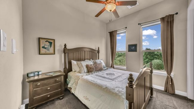 Bedroom featuring dark colored carpet, baseboards, ceiling fan, and multiple windows | Image 31