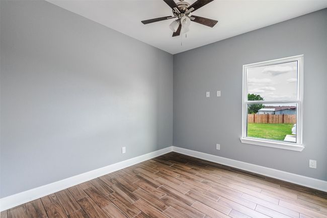 Empty room featuring baseboards, dark wood-style floors, and a ceiling fan | Image 20