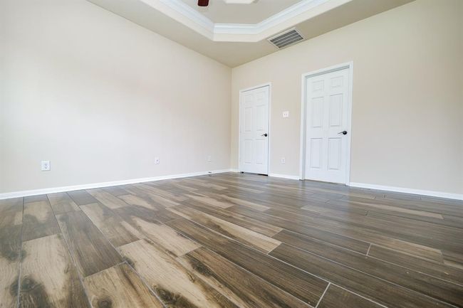 Incredible wall and floor space is embraced by the intimacy of a tray ceiling in the primary suite. | Image 13