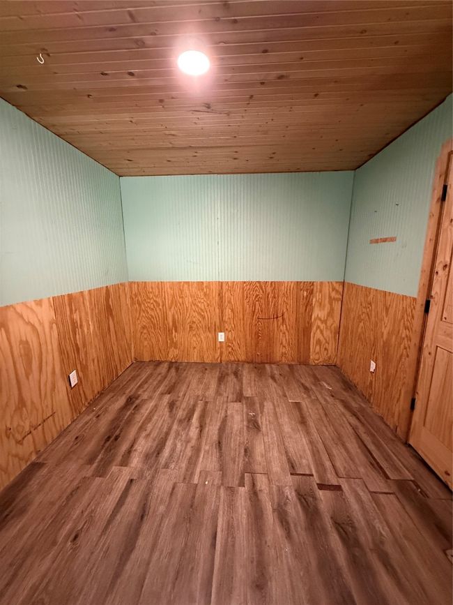 Empty room with wooden ceiling, wood finished floors, and wooden walls | Image 27