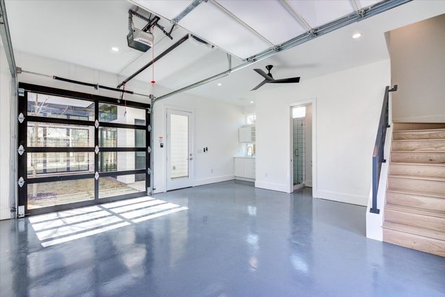 The garage/flex space is climate controlled and has epoxy floors, so it could be used as additional living space. The glass garage doors connect the space to the middle yard / courtyard. | Image 5