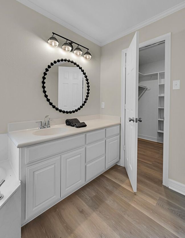 Bathroom with a tub to relax in, wood finished floors, and 2 walk in closets | Image 23