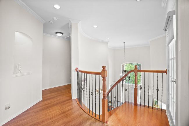 Hallway featuring an upstairs landing, wood finished floors, recessed lighting, ornamental molding, and a chandelier | Image 23