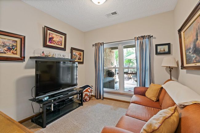 Versatile bonus room offers endless possibilities for your lifestyle needs. This downstairs room could serve as a home theater for movie nights, a quiet study or home office, a children's playroom, a nursery or even a guest bedroom. The flexible layout and convenient main-floor location make it perfect for adapting to your family's changing needs over time. | Image 15