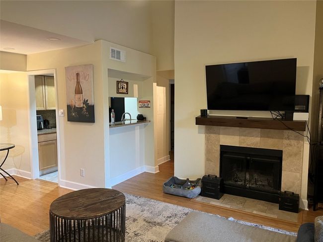 Living room with wood finished floors and a tile fireplace | Image 16