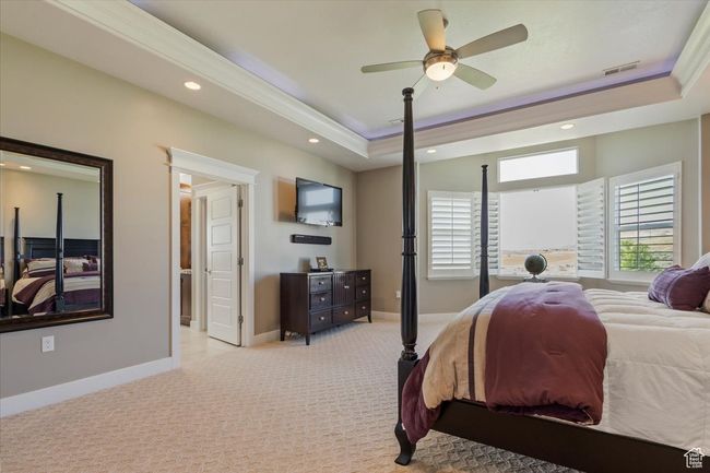Bedroom featuring light carpet, a tray ceiling, recessed lighting, baseboards, and ceiling fan | Image 30