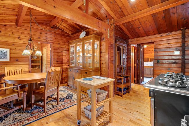 Dining room with wood walls, wood ceiling, and light wood finished floors | Image 10