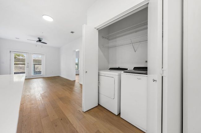 Washroom with laundry area, a ceiling fan, light wood finished floors, and washer and clothes dryer | Image 10