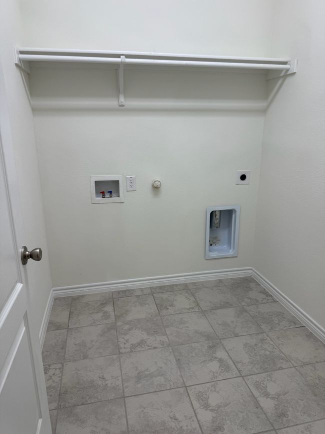 Laundry room featuring gas dryer hookup, hookup for a washing machine, baseboards, and hookup for an electric dryer | Image 24