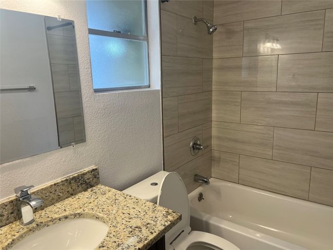 Bathroom featuring a textured wall, vanity, and tub / shower combination | Image 12