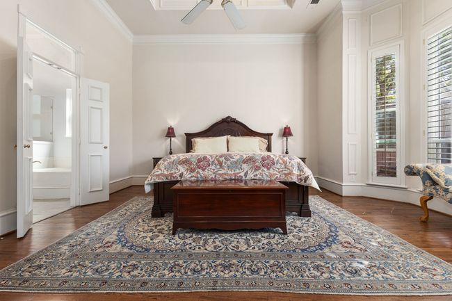 Bedroom with a ceiling fan, baseboards, ornamental molding, and wood finished floors | Image 17