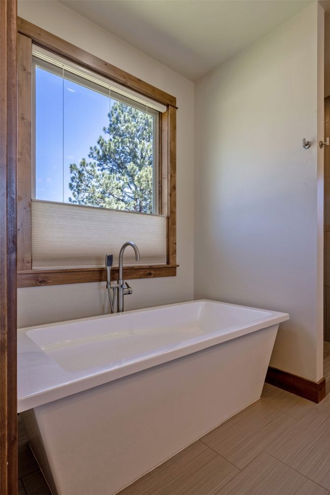 Full bathroom featuring a freestanding tub and baseboards | Image 20