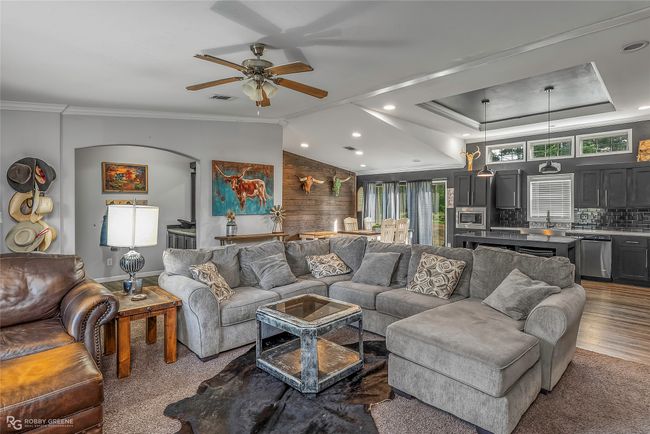 Living room featuring crown molding, arched walkways, recessed lighting, wood finished floors, and a ceiling fan | Image 13