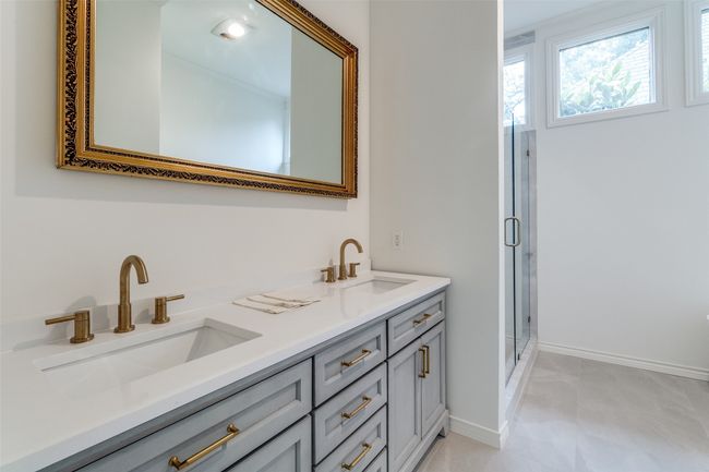 Full bathroom featuring double vanity, a stall shower, and baseboards | Image 17