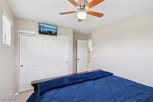 Bedroom featuring a closet, light carpet, ceiling fan, and baseboards | Image 44