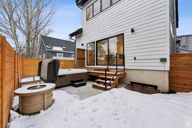 Snow covered patio featuring a hot tub and a fire pit | Image 13