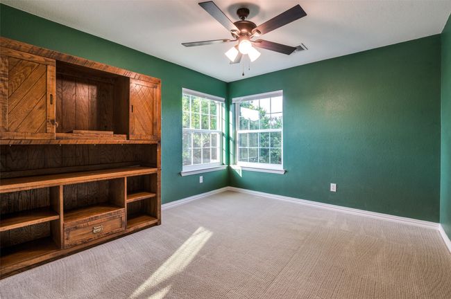 Secondary bedroom upstairs with decorator color, attached bookcase and shelves | Image 32