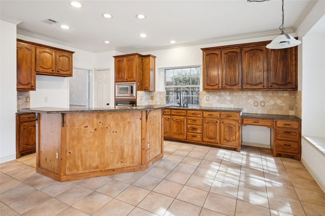 Center cooking Island and kitchen with lots of cabinets for storage and kitchen planning desk | Image 16