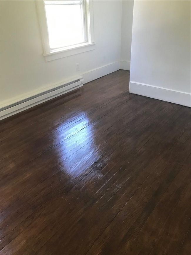 Unfurnished room featuring a baseboard heating unit and dark hardwood / wood-style floors | Image 24