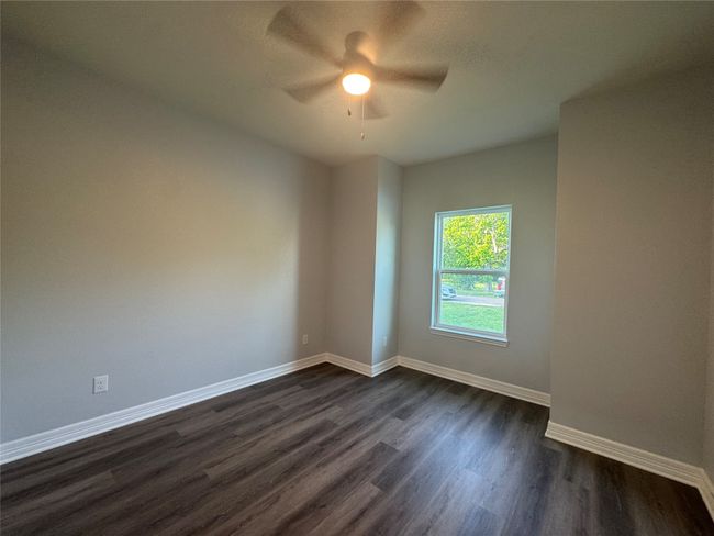 Spare room featuring a ceiling fan and dark wood-style floors | Image 27