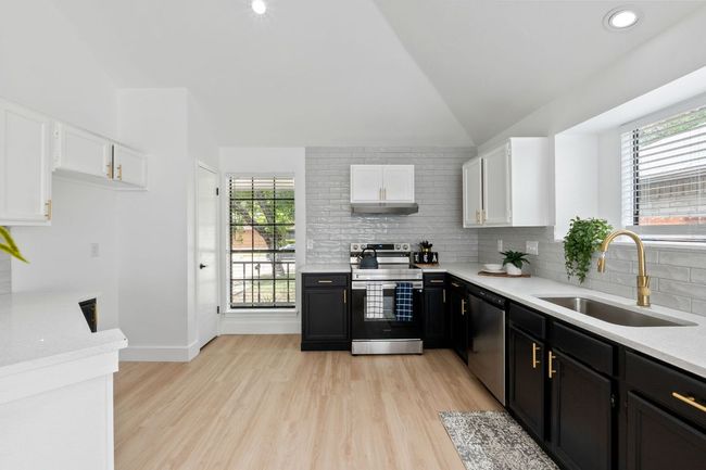 Kitchen with tasteful backsplash, a sink, stainless steel appliances, and lofted ceiling | Image 13