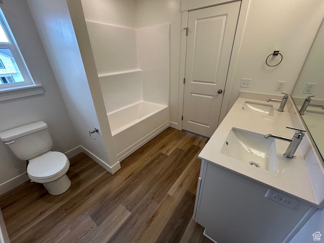Bathroom featuring double vanity, wood finished floors, and shower / bathtub combination | Image 9