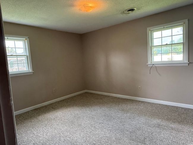 Spare room featuring a textured ceiling, carpet floors, and baseboards | Image 8