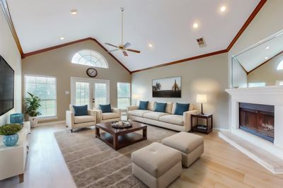 Living room featuring ceiling fan, high vaulted ceiling, hardwood / wood-style floors, ornamental molding, and french doors | Image 2