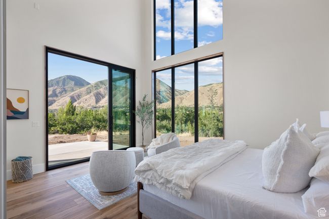 Bedroom featuring access to exterior, a mountain view, wood finished floors, and a high ceiling | Image 38