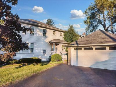 View of back of home featuring a garage and a side yard | Image 3