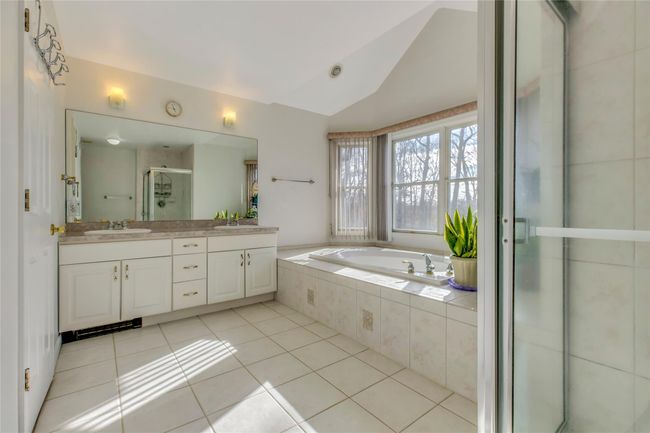 Bathroom with lofted ceiling, vanity, tile patterned floors, and plus walk in shower | Image 19