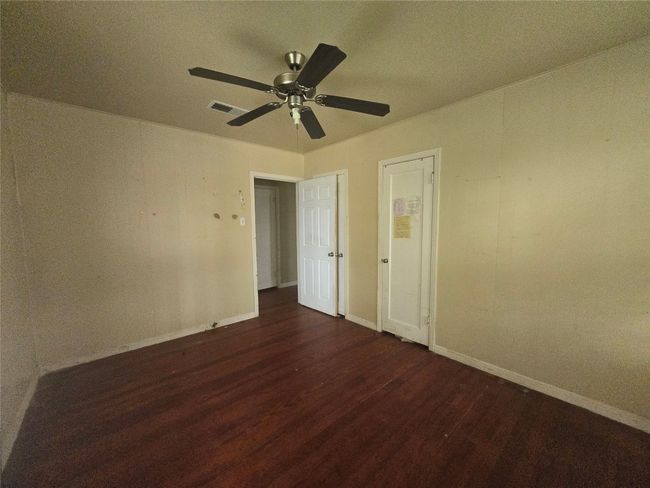 Spare room with dark wood finished floors, baseboards, and a ceiling fan | Image 10
