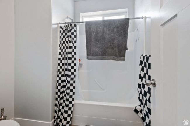 Bathroom featuring shower / bath combination with curtain | Image 11