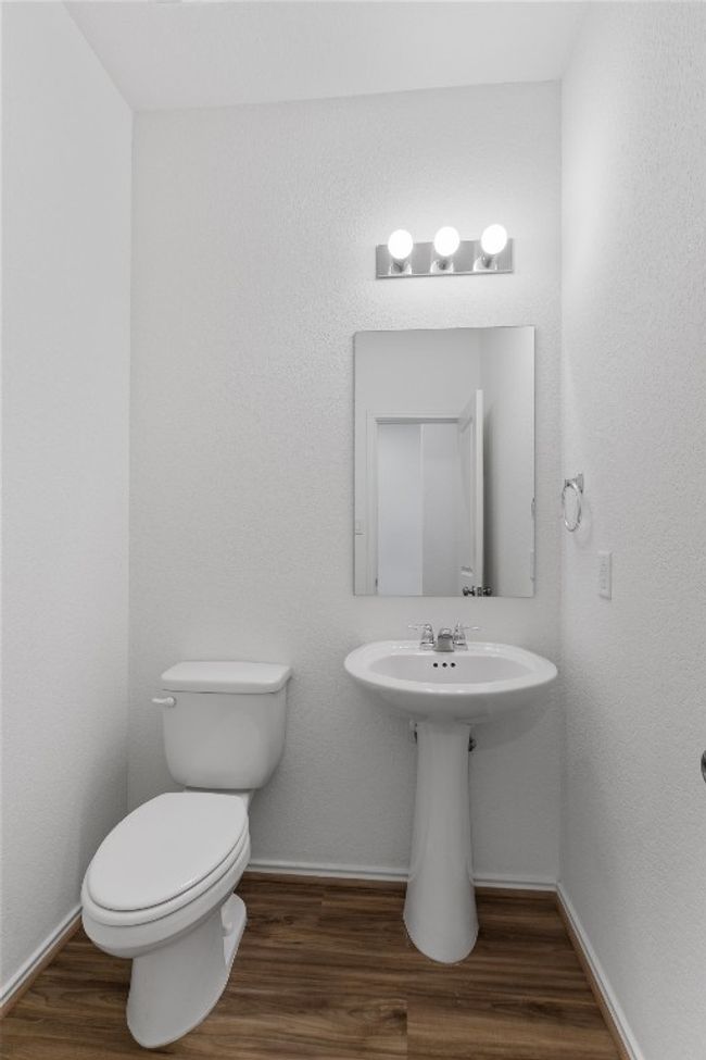 Half bathroom with wood finished floors, toilet, and baseboards | Image 19