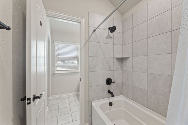Bathroom with shower combination, tile patterned flooring, and vaulted ceiling | Image 29