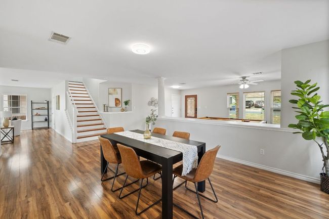 Dining area with wood finished floors, stairs, and baseboards | Image 9