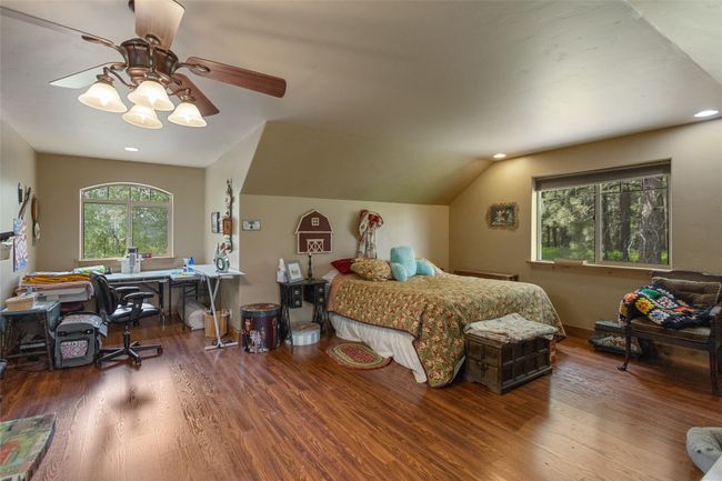 Bedroom with wood finished floors, a desk, ceiling fan, recessed lighting, and lofted ceiling | Image 37