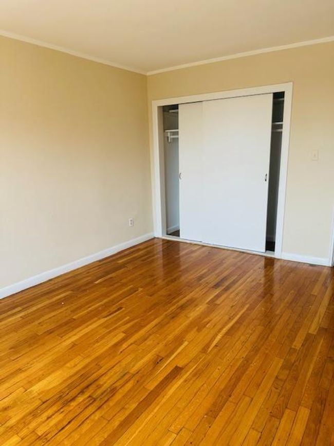 Unfurnished bedroom featuring crown molding, hardwood / wood-style floors, and a closet | Image 8